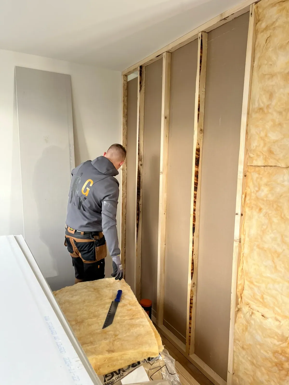 Tømrer sætter gips og isolering op på ny skillevæg